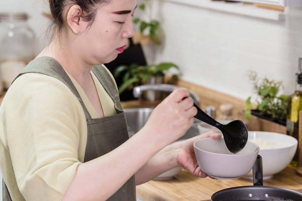 Ilustrasi proses memasak kuah cuko di dapur menggunakan peralatan masak sebagai pelengkap sajian khas Palembang.