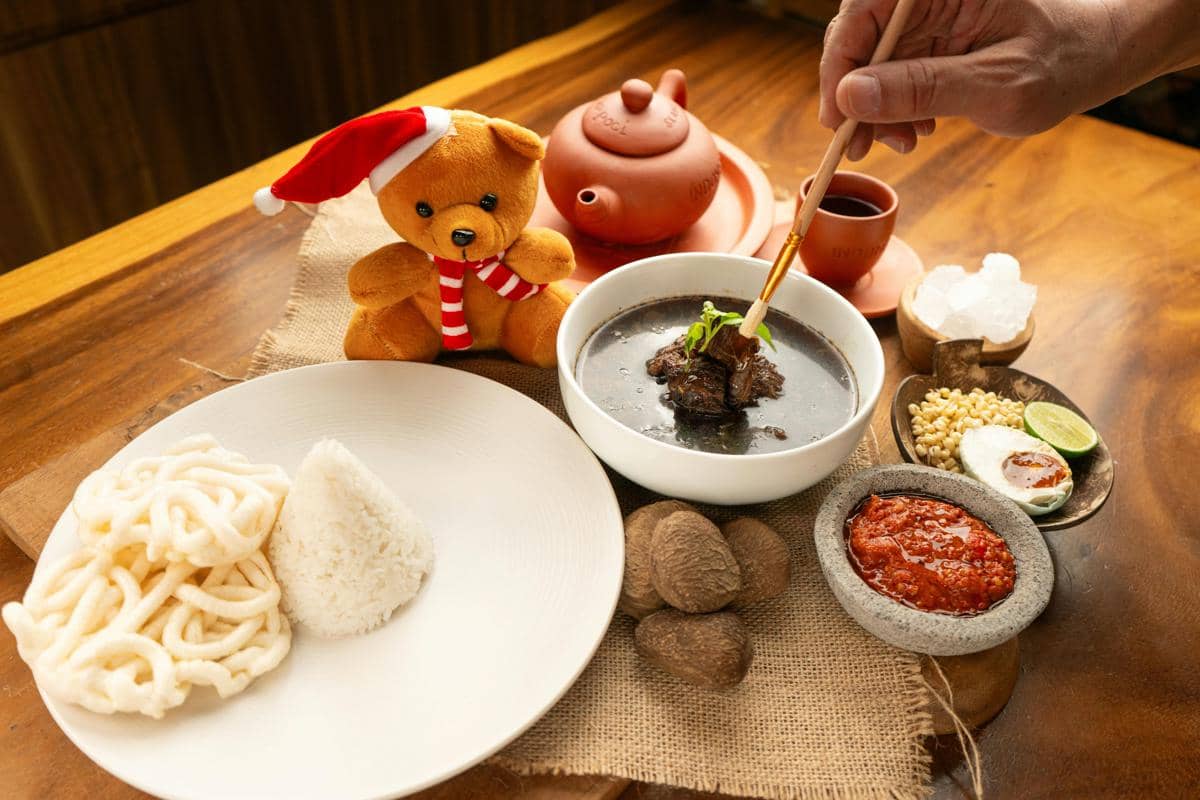 Ilustrasi semangkuk rawon dengan nasi dan lauk pendamping.