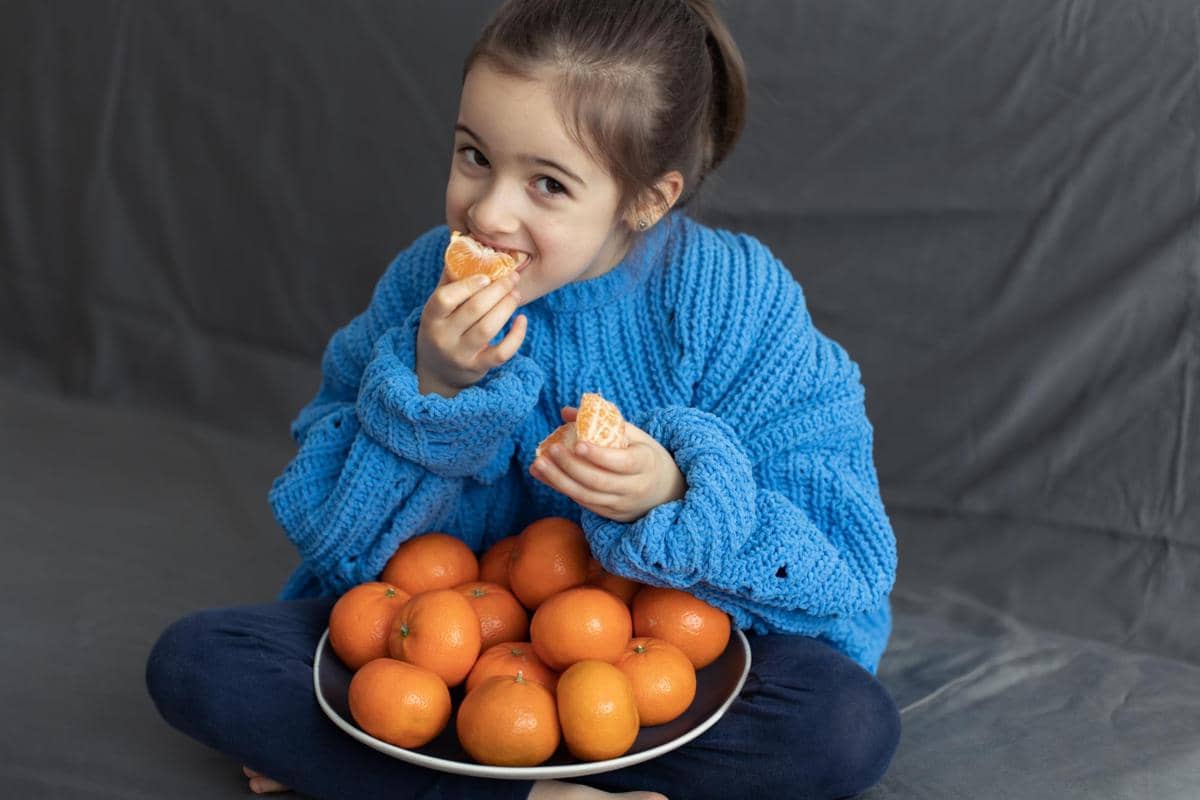 ilustrasi makan jeruk mandarin 