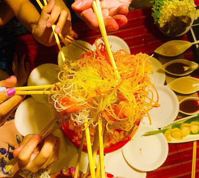 ilustrasi tradisi Yusheng yang identik dengan perayaan Imlek