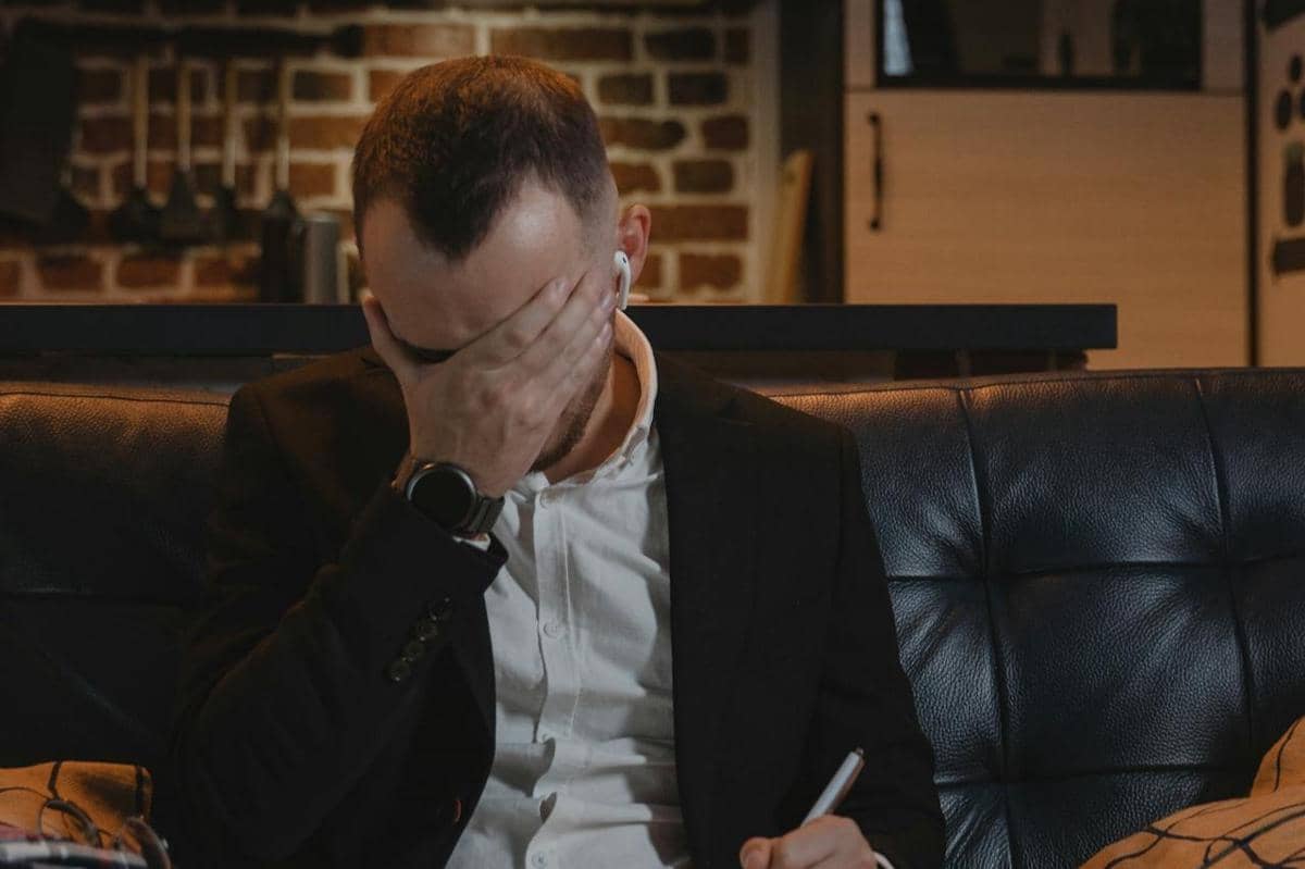 Seorang pria sedang menulis surat sambil menangis.