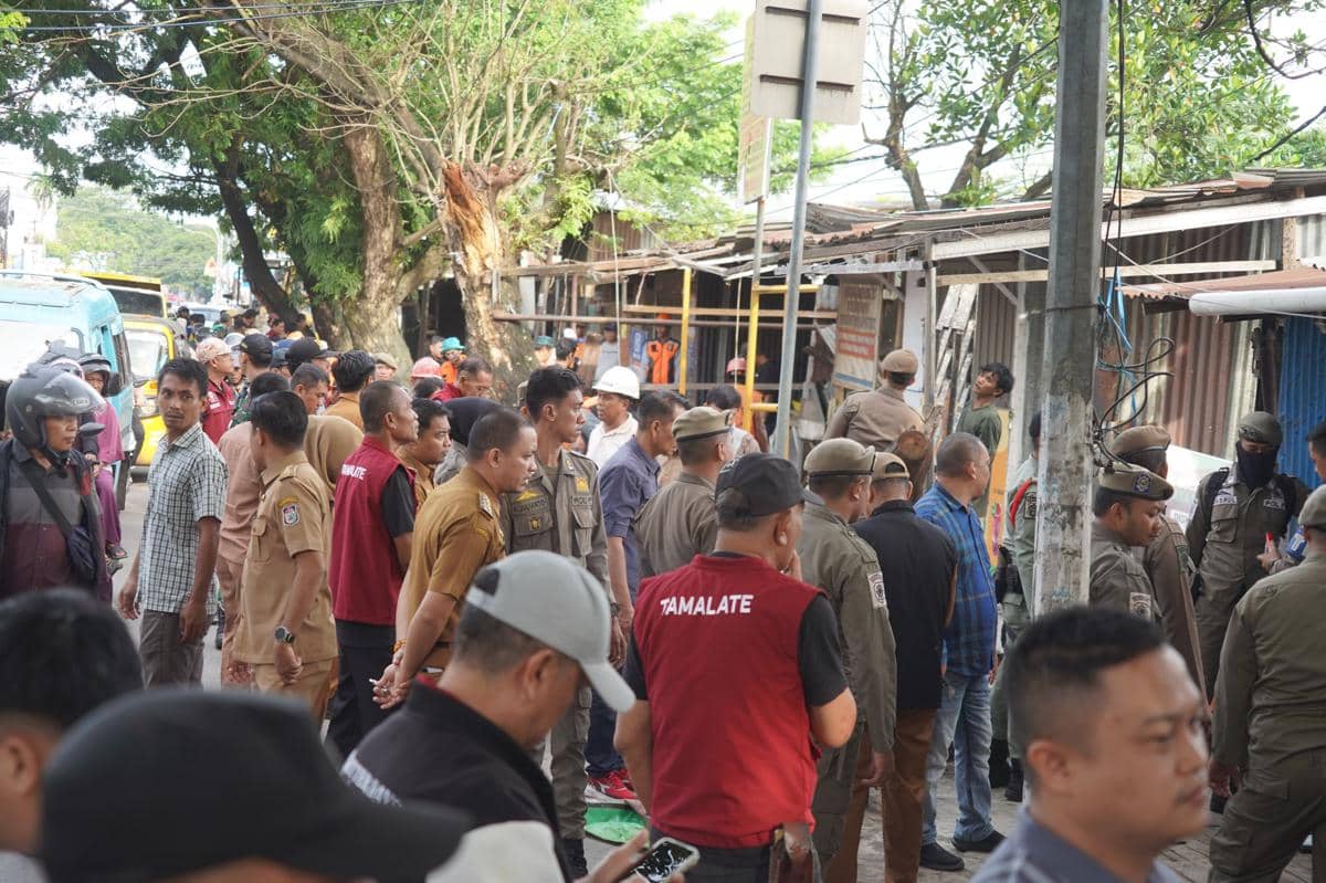 Petugas Satpol PP bersama aparat Kecamatan Tamalate menertibkan lapak PKL yang berdiri di atas trotoar dan menutup drainase di Jalan Daeng Tata Raya, dan Jalan Sultan Alauddin, Makassar, Senin (16/2/2026). (Dok. Pemkot Makassar) 