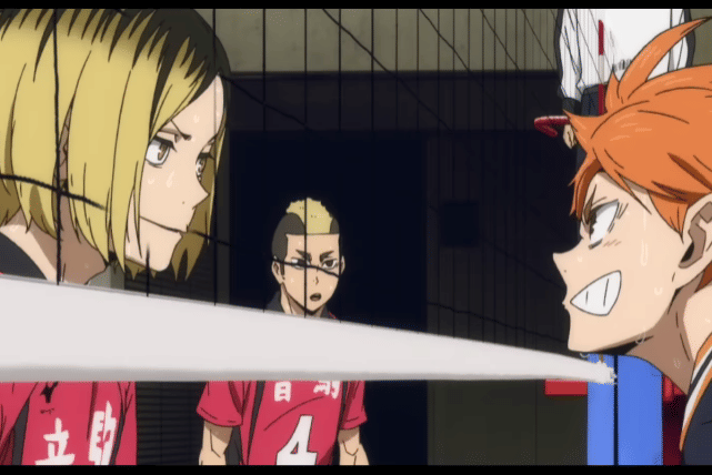 Kenma Kozume dan Shoyo Hinata saling berhadapan di lapangan voli dengan ekspresi serius, dipisahkan oleh net pertandingan.
