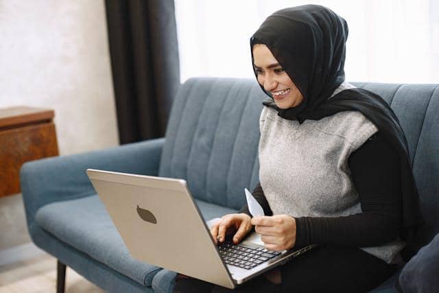 Photo by Gustavo Fring: https://www.pexels.com/photo/smiling-woman-in-hijab-with-a-laptop-on-a-sofa-8770682/