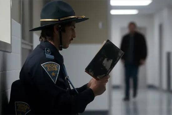 cuplikan adegan seorang polisi membaca buku Cujo karya Stephen King dalam Stranger Things