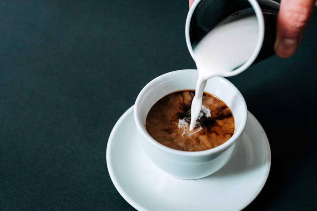 Ilustrasi menuangkan krimer ke gelas kopi