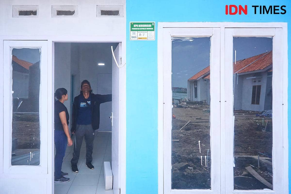 Ekosistem Inklusif BTN - Giyarto (45) (kanan), pedagang mi ayam dan bakso keliling, mengecek rumah bersubsidi milik adiknya, Adinda Rizky Arbaningrum, bersama staf pemasaran PT Songolas Jaya Abadi, Fenny (kiri), di Kabupaten Kendal, Jawa Tengah, Kamis (12/2/2026). Ekosistem perumahan inklusif Bank BTN terbukti sukses memperluas akses pembiayaan dan mewujudkan hak hunian layak bagi buruh perempuan dan pekerja informal di kawasan penyangga industri. (IDN Times/Dhana Kencana)