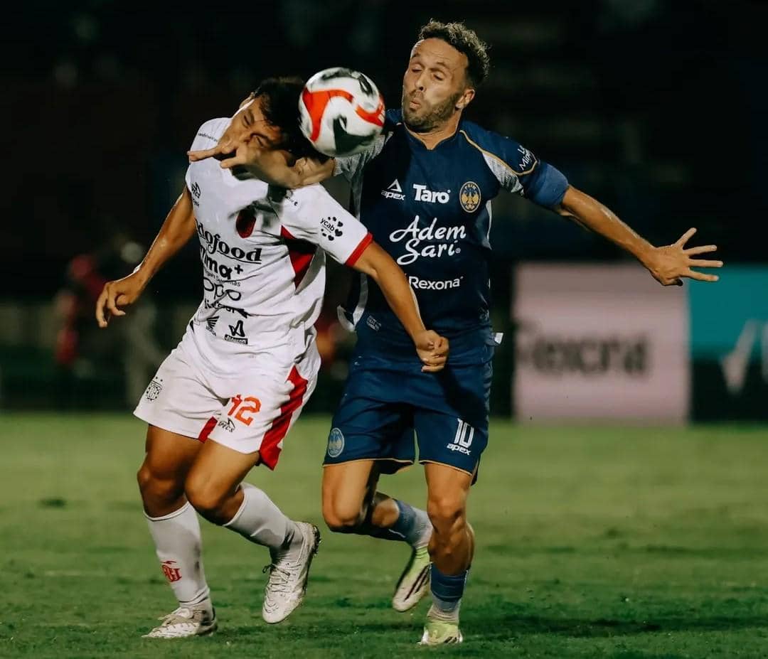Pemain Bali United (putih) mendapatkan pengawalan dari pemain PSIM Yogyakarta (biru).