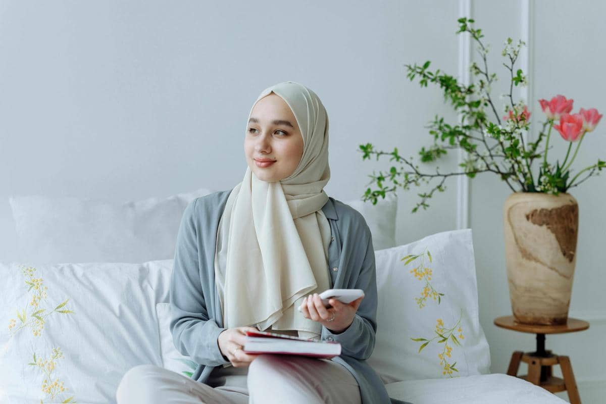 ilustrasi hijabers memegang buku dan handphone