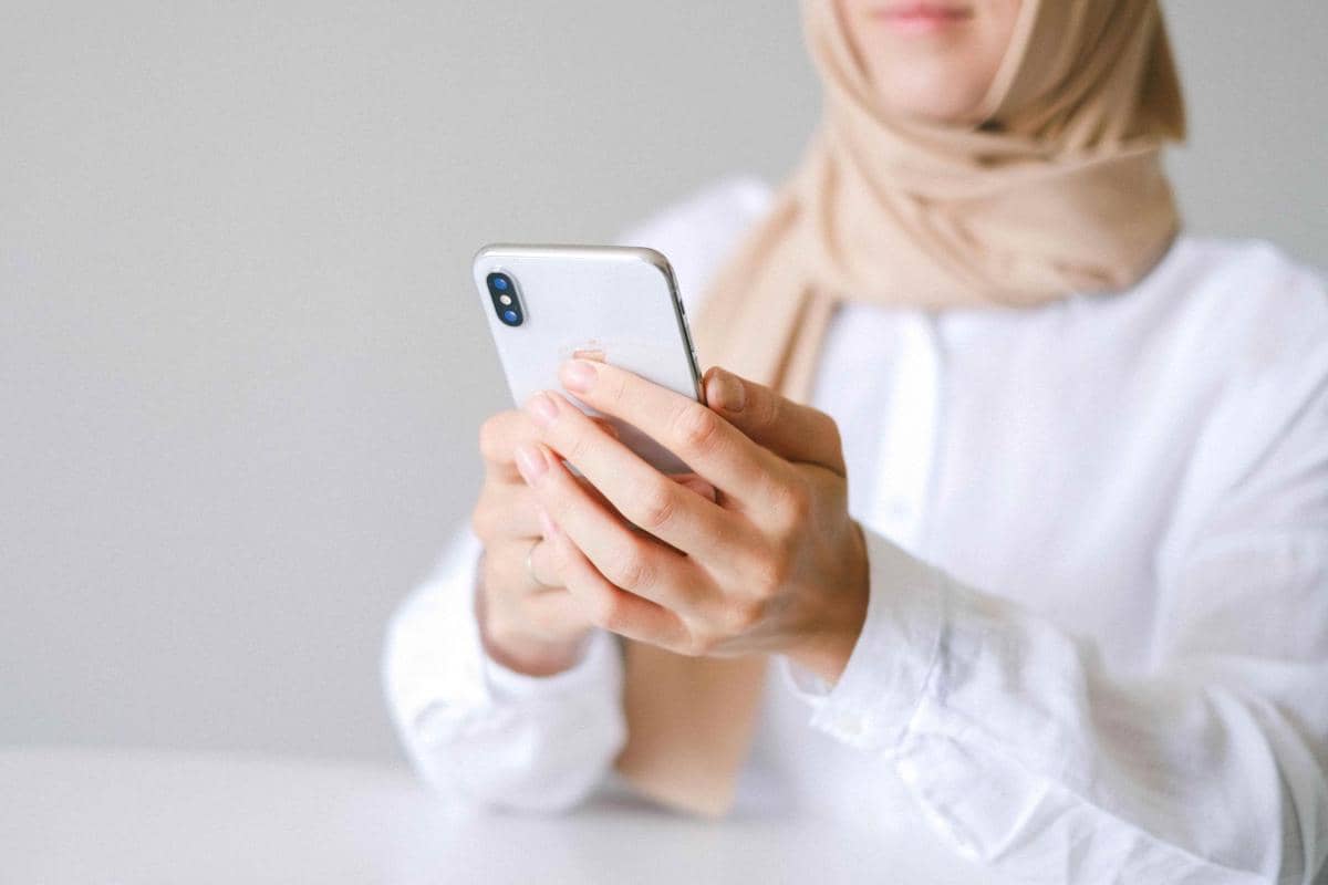 ilustrasi hijaber fokus bermain handphone 