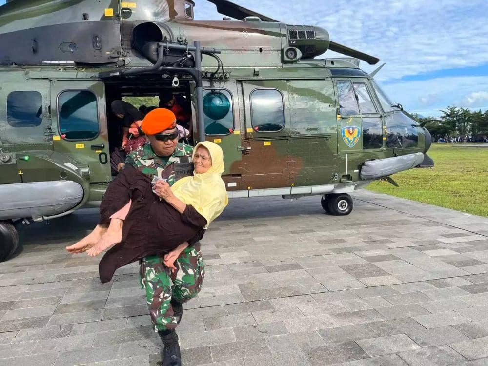 Personel TNI menggendong seorang nenek-nenek