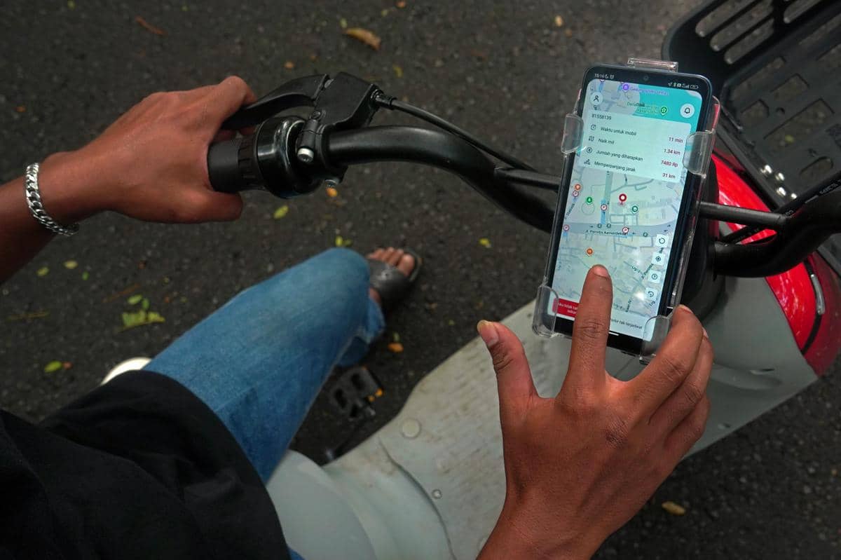 Mahasiswa melihat rute perjalanan sepeda listrik menggunakan aplikasi di kawasan Universitas Hasanuddin, Makassar, Sulawesi Selatan, Senin (23/2/2026). (ANTARA FOTO/Hasrul Said)