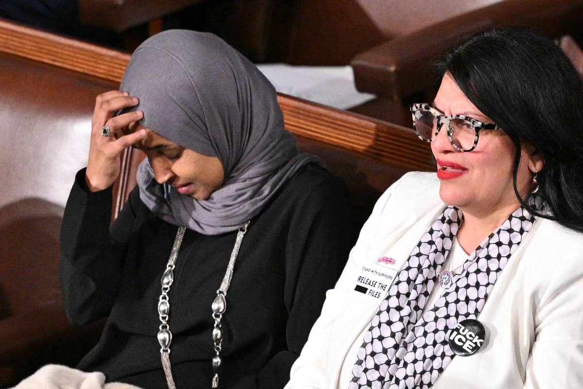 (Ki-Ka) Perwakilan AS Ilhan Omar, Demokrat dari Minnesota, dan Rashida Tlaib, Demokrat dari Michigan, memperhatikan saat Presiden Donald Trump menyampaikan pidato Kenegaraan di Ruang Sidang DPR di Gedung Capitol AS di Washington, DC, pada 24 Februari 2026. 