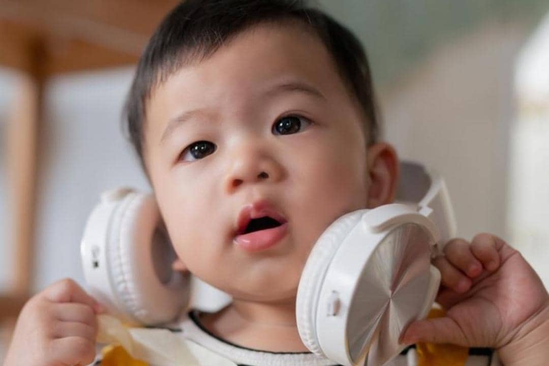 Ilustrasi bayi menggunakan earmuff 