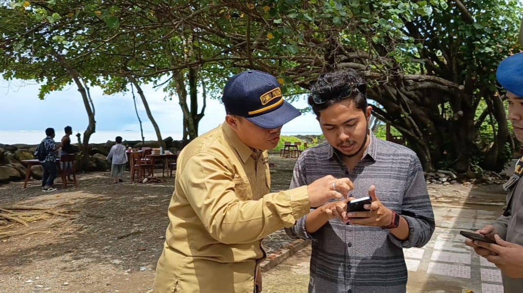 Personel Satpol PP Padang memperlihatkan aturan kepada pemilik usaha