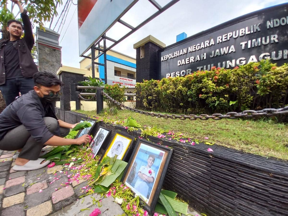 Mahasiswa menabur bunga di foto korban kekerasan oknum polisi. IDN Times/Bramanta Pamungkas