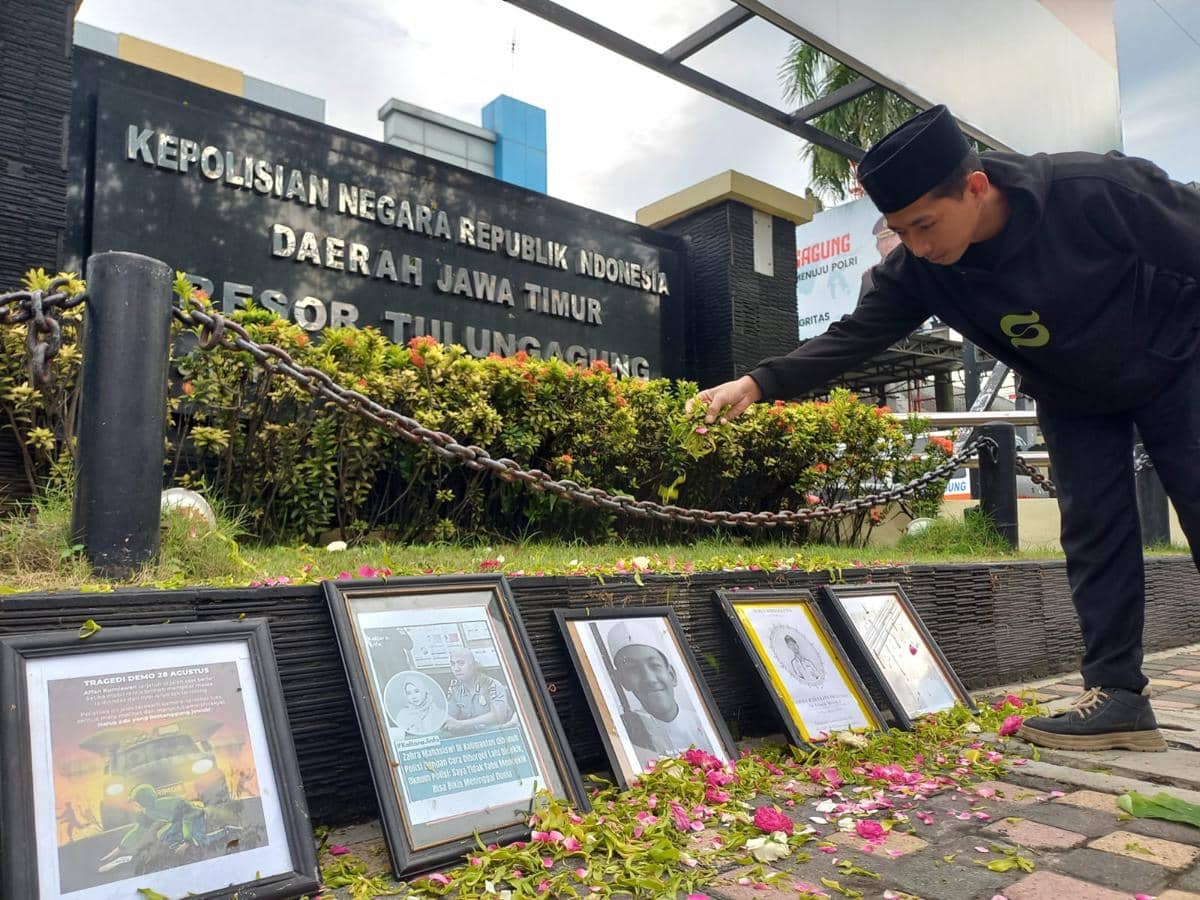 Mahasiswa menabur bunga di foto korban kekerasan oknum polisi. IDN Times/Bramanta Pamungkas