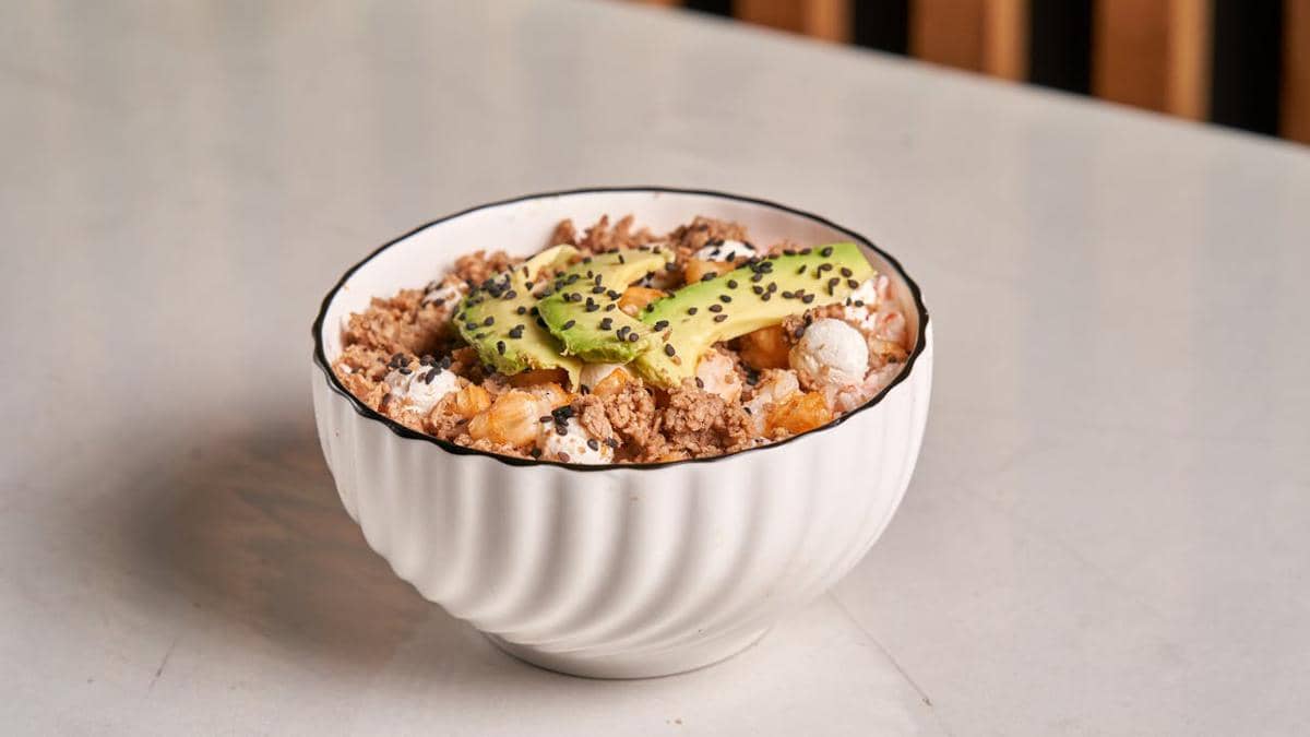 Oatmeal dengan topping alpukat dan kacang-kacangan. 