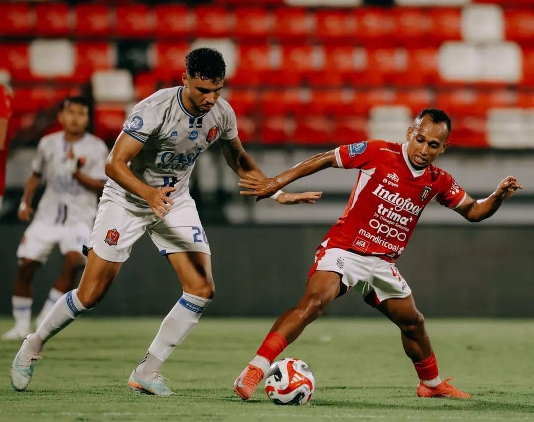 Irfan Jaya (merah) saat berusaha melewati hadangan pemain Persijap Jepara (putih)