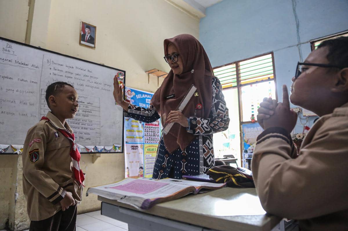 Seorang guru menyampaikan materi pelajaran Pendidikan Agama Islam (PAI) kepada siswa dalam kegiatan belajar mengajar di SD Negeri Kalicari 3, Semarang, Jawa Tengah. (ANTARA FOTO/Makna Zaezar)