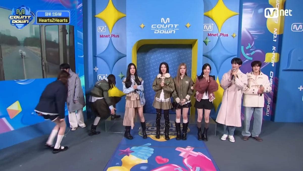 Carmen berjalan sopan dengan membungkuk dan memperlihatkan gestur tangan yang khas kebiasaan warga Indonesia saat tampil untuk interview acara musik M Countdown