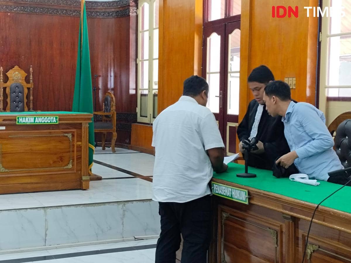 Topan Ginting di sidang tuntutan saat berdiskusi dengan penasehat hukumnya (IDN Times/Eko Agus Herianto)