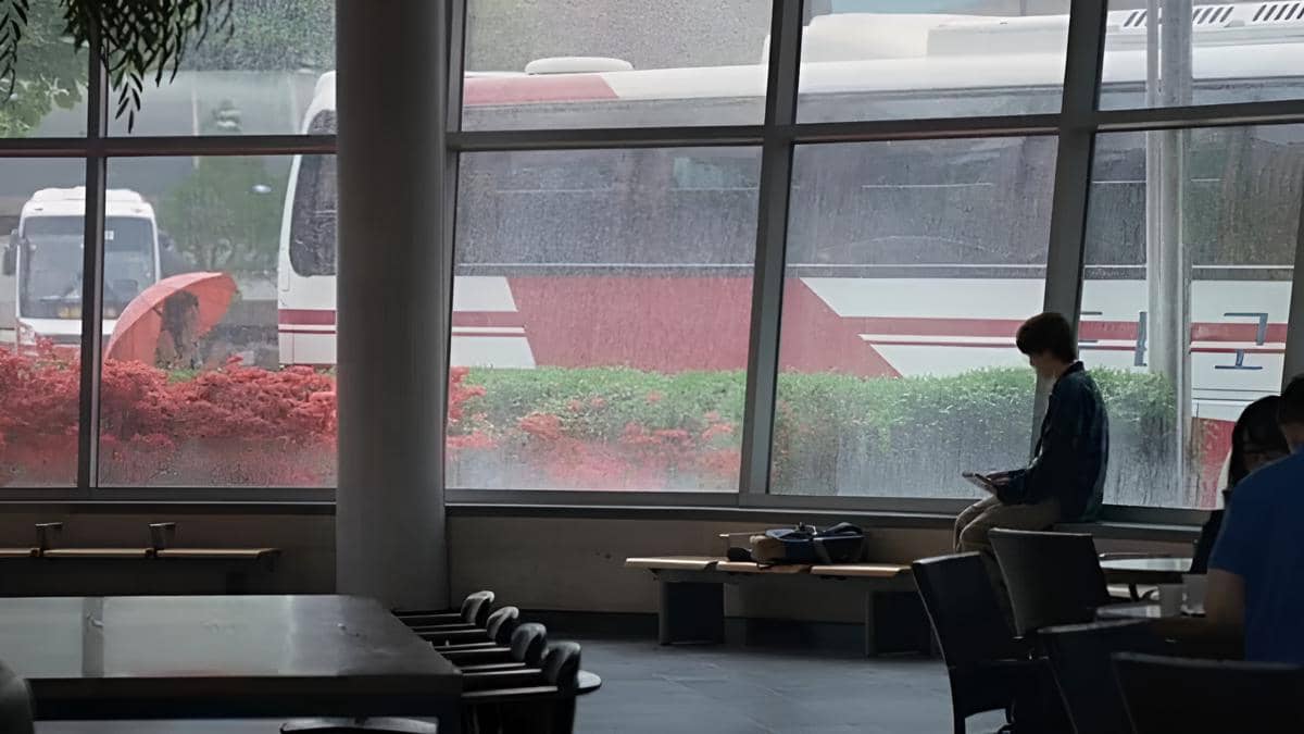 Eun Ho menggambar Jeong Won yang sedang berdiri di bawah hujan dengan payung merah.