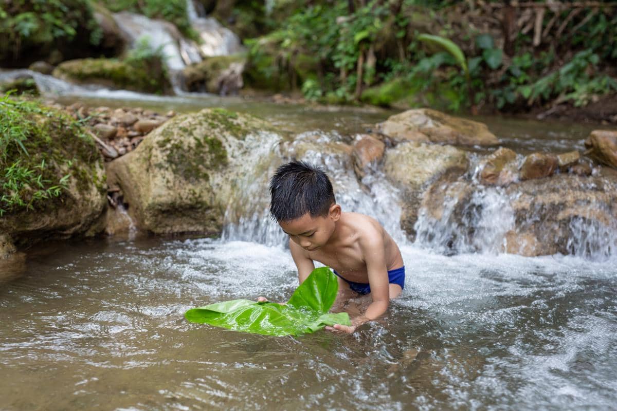 Ilustrasi Kolam sumber mata air Umbulan Tanaka dengan air jernih dan suasana alam yang tenang.