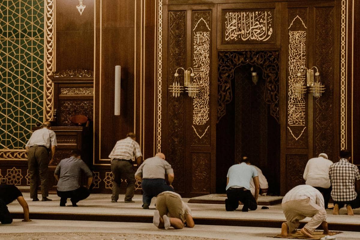 Ilustrasi masjid di pusat kota dengan aktivitas jemaah Ramadan. 