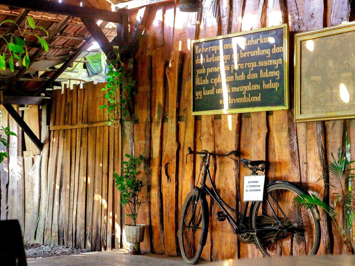 A bicycle is parked against a wooden wall