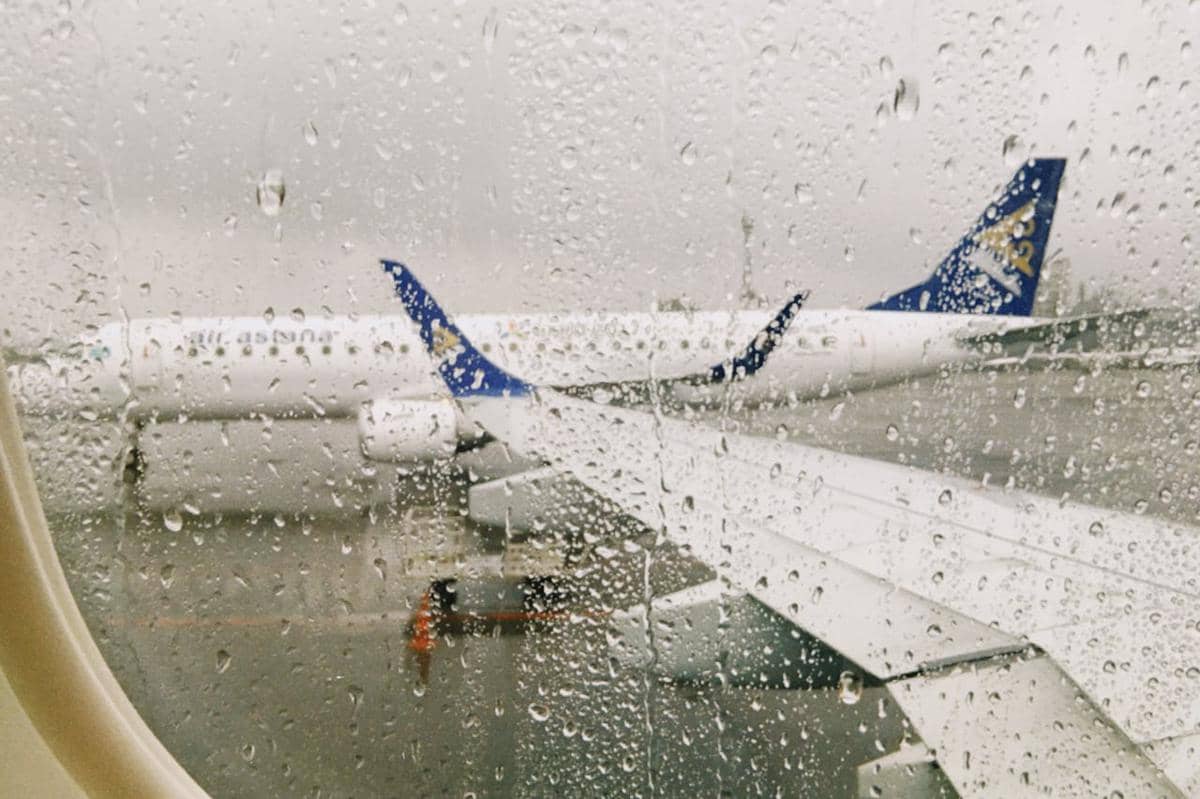 ilustrasi pesawat yang berada di tengah hujan