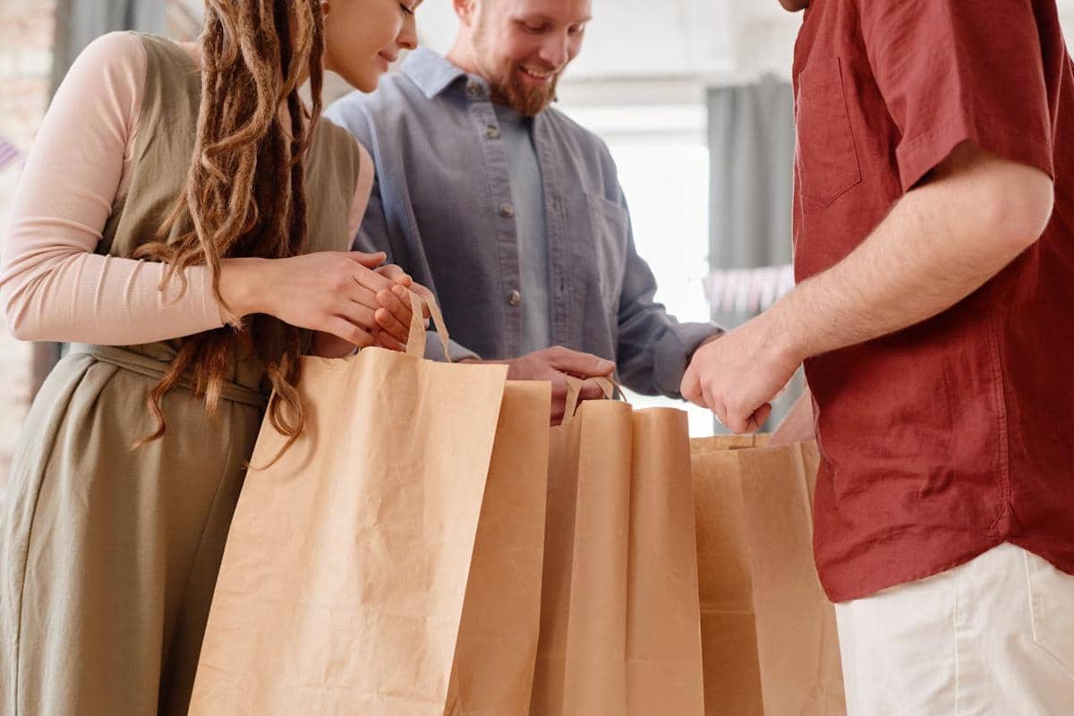 ilustrasi orang-orang memegang kantong kertas