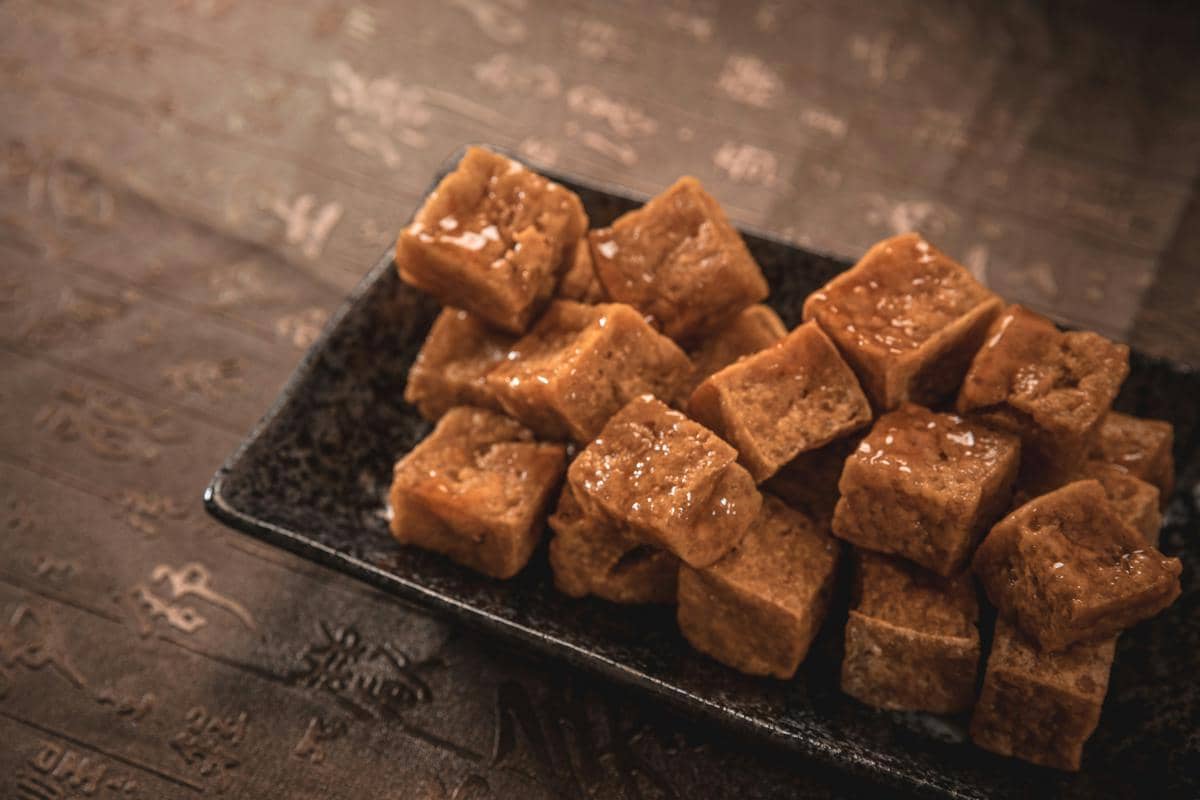 Salted caramels are piled on a black plate