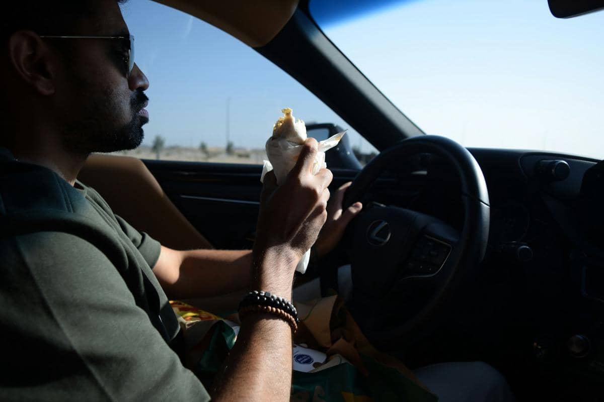 ilustrasi pria makan di mobil