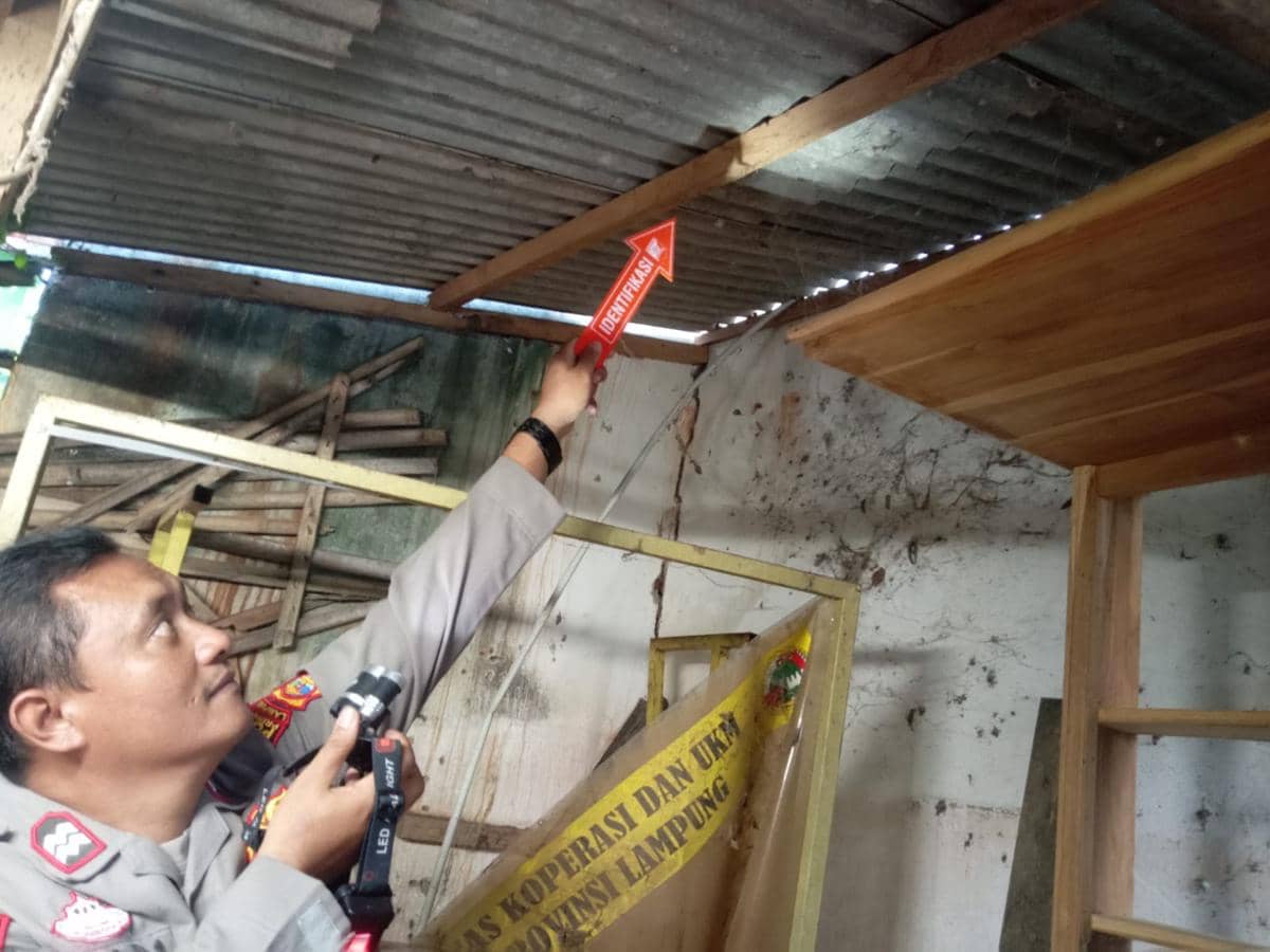 Polisi mengevakuasi jenazah korban S di teras samping sebuah rumah di Pekon Podosari, Kecamatan Pringsewu. 