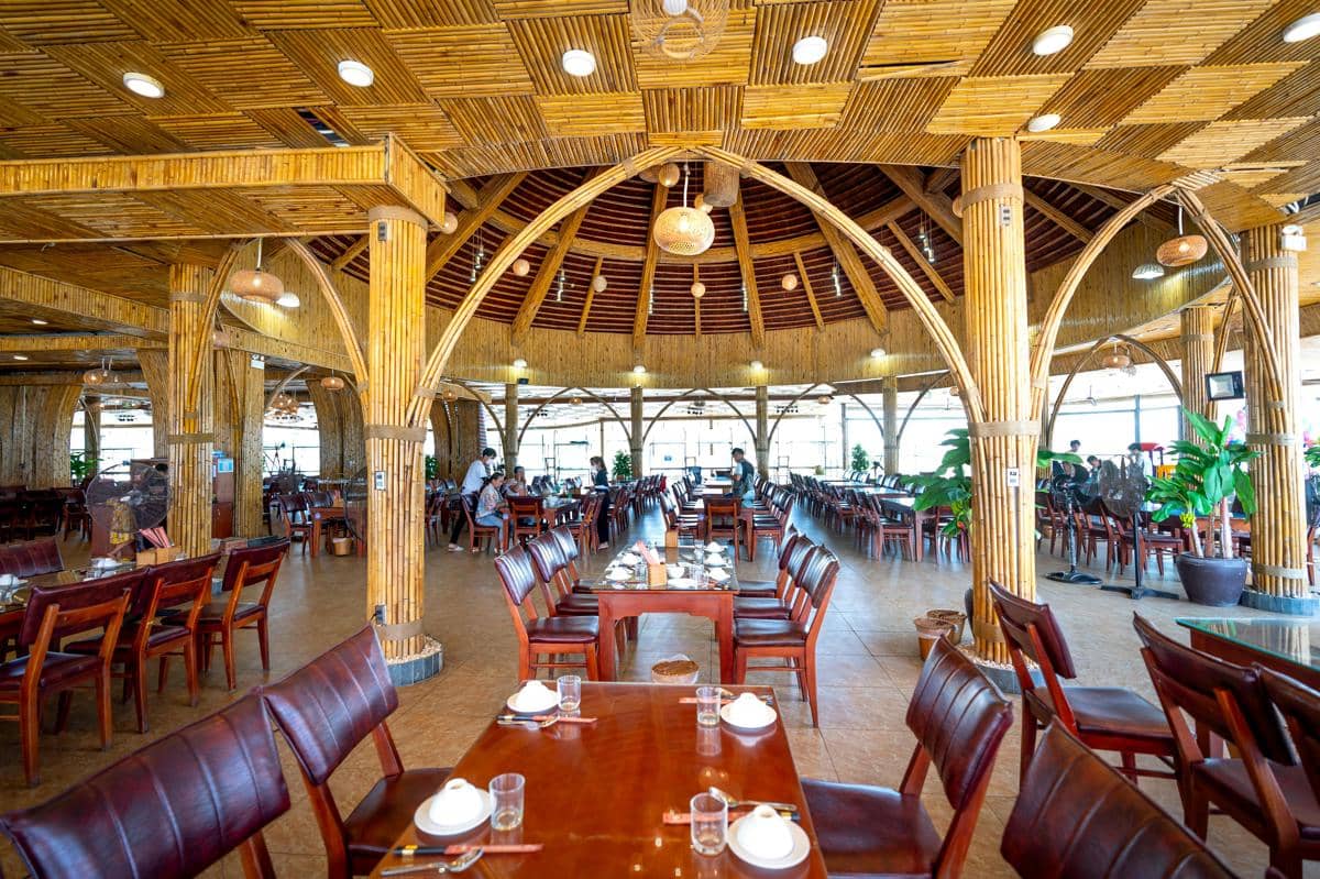 Ilustrasi restoran keluarga luas dengan meja makan besar dan suasana ramai.