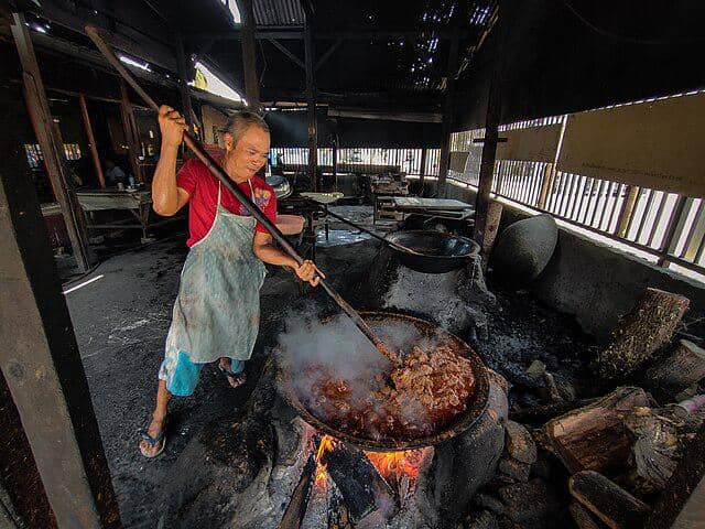 ilustrasi memasak rendang secara tradisional 