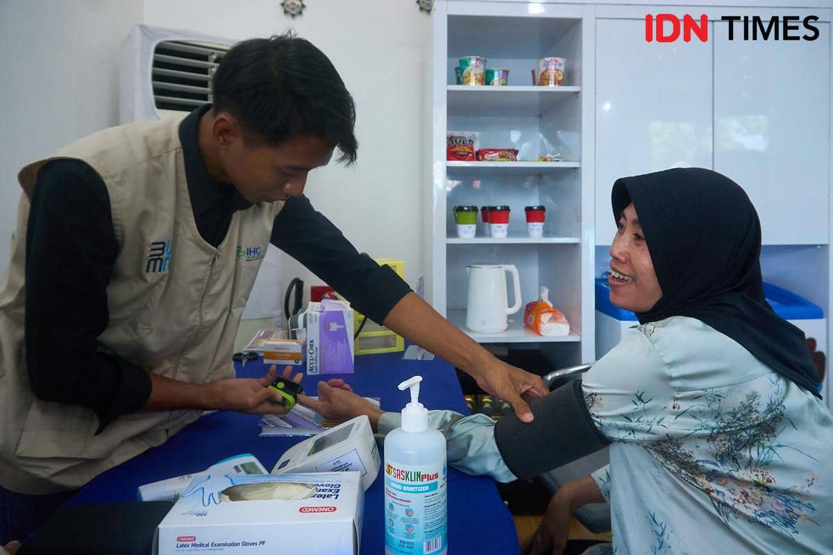 Pemudik, Ariyani (kanan) menikmati layanan tes kesehatan di Serambi MyPertamina di Rest Area KM 379A Tol Semarang–Batang (arah Jakarta ke Semarang), Rabu (18/3/2026). (IDN Times/Dhana Kencana)