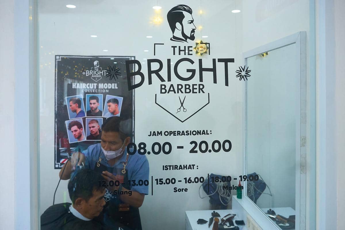 Pemudik menikmati layanan potong rambut gratis di Serambi MyPertamina di Rest Area KM 379A Tol Semarang–Batang (arah Jakarta ke Semarang), Rabu (18/3/2026). (IDN Times/Dhana Kencana)