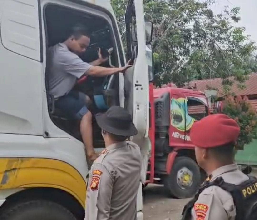 Personel Polres Muba saat menghentikan kendaraan sumbu tiga yang nekat melintas di Jalintim saat arus balik Lebaran. 