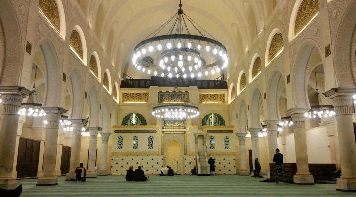 Aula salat Masjid Ketchaoua dengan mihrab di bagian depan, dikelilingi pilar dan lengkungan interior.