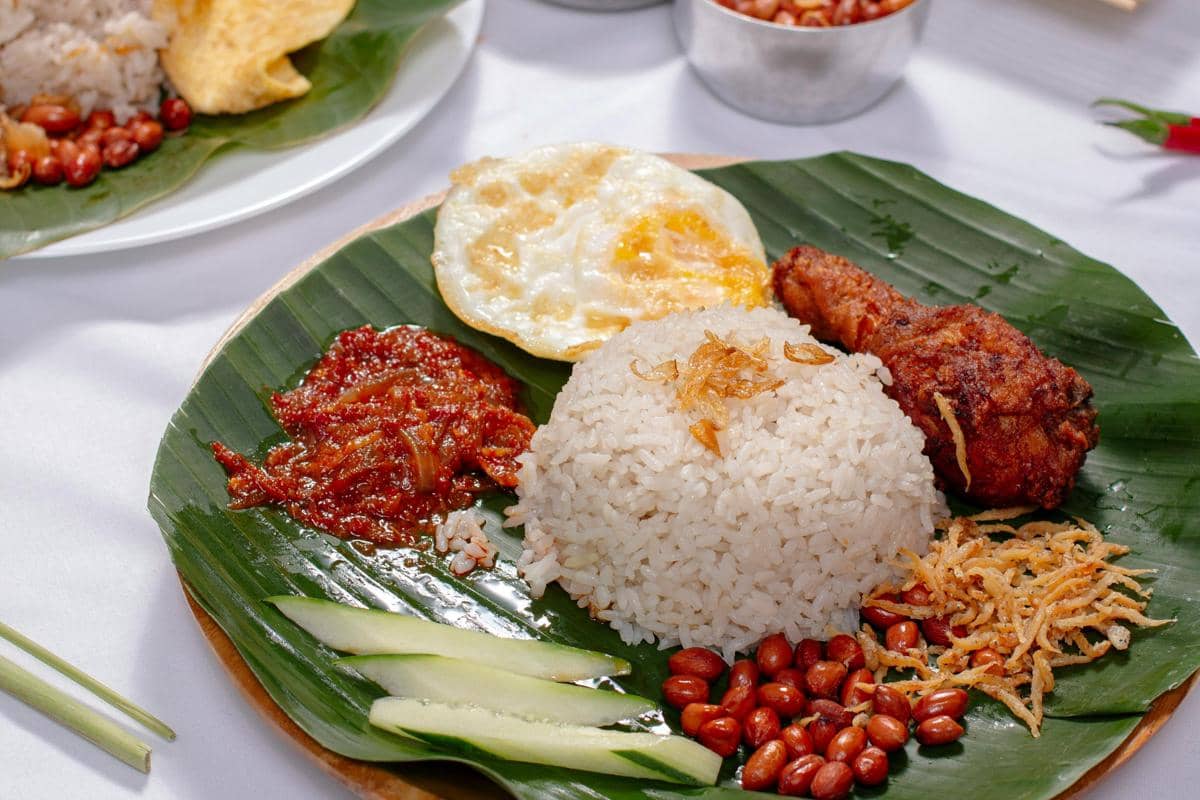 Ilustrasi nasi boranan dengan lauk lengkap dan sambal khas.