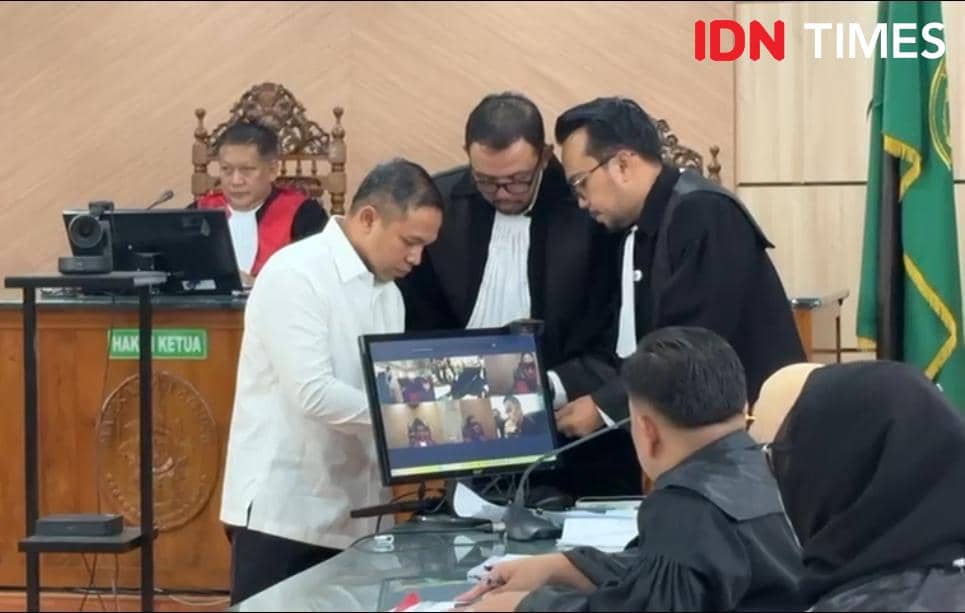 Gubernur Riau nonaktif Abdul Wahid saat berkonsultasi dengan tim penasehat hukumnya untuk mengajukan eksepsi (IDN Times/ Fanny Rizano)