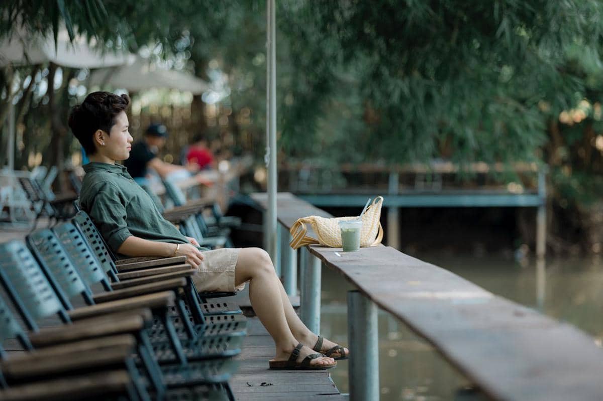 Ilustrasi orang duduk di tepi danau