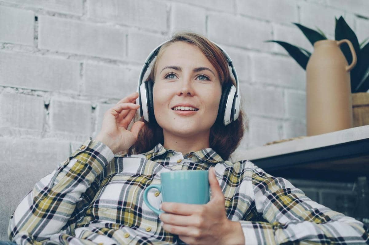 seorang wanita sedang mendengarkan musik sambil bersantai