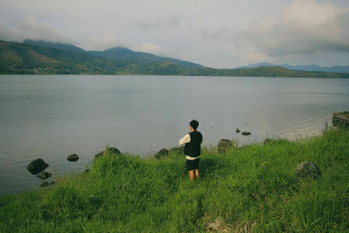 Ilustrasi danau tenang dengan latar Gunung Lemongan dan suasana pagi yang sejuk.
