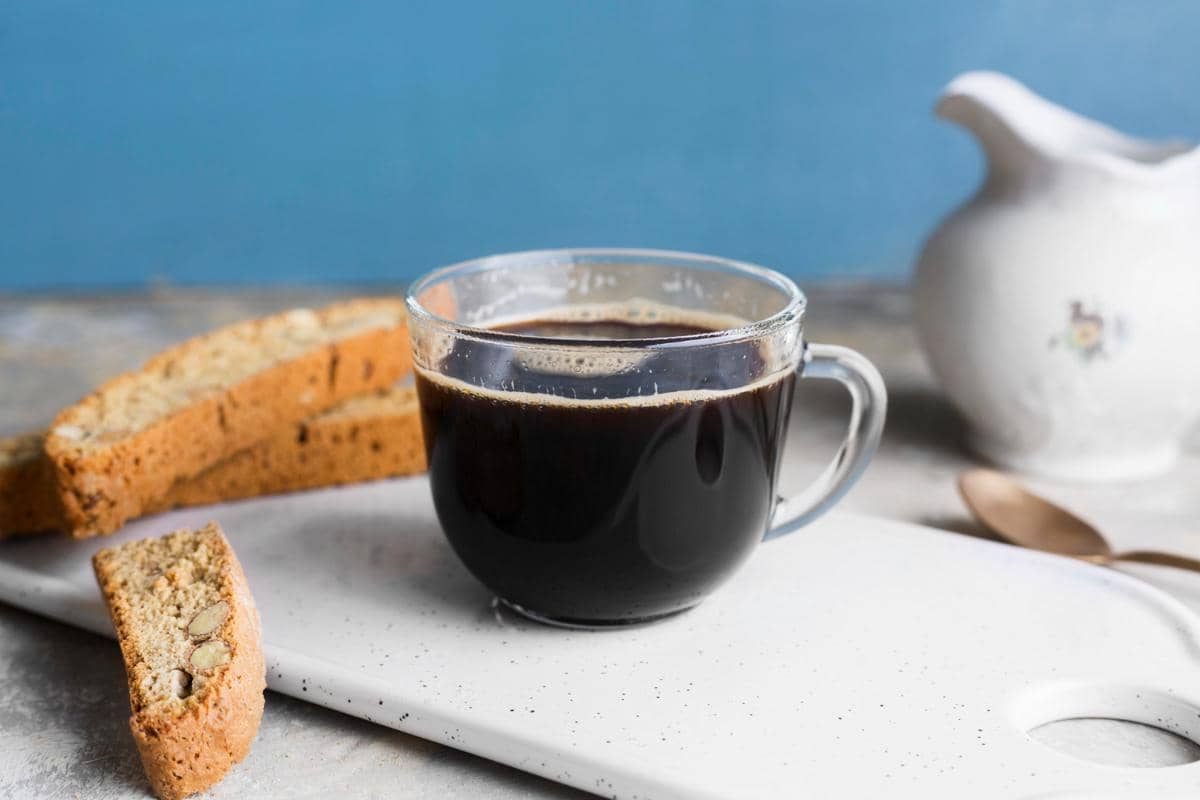 Ilustrasi secangkir kopi hitam berwarna gelap dalam cangkir, merepresentasikan minuman kopi sederhana.