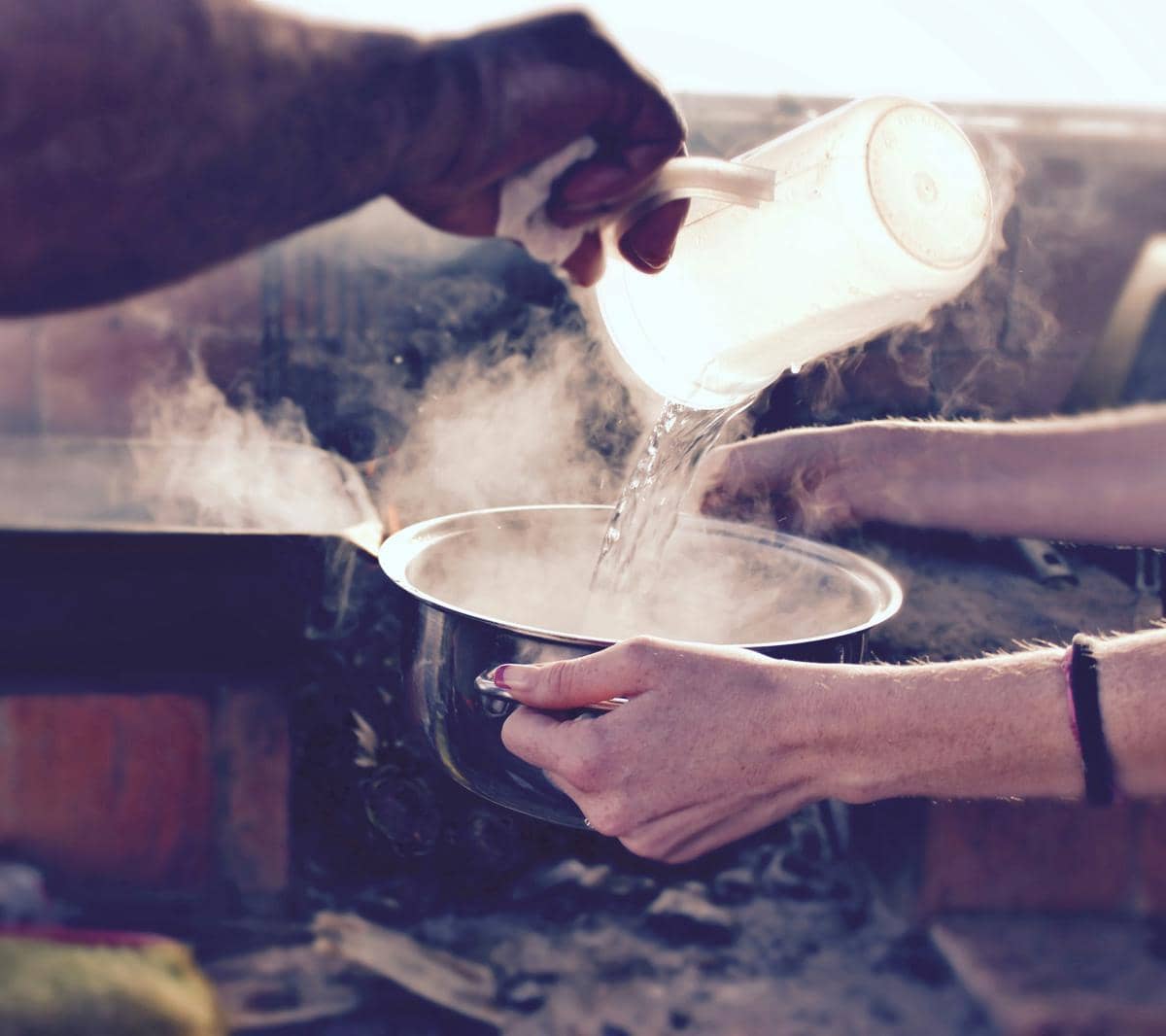 Air panas dituangkan dalam panci untuk memasak