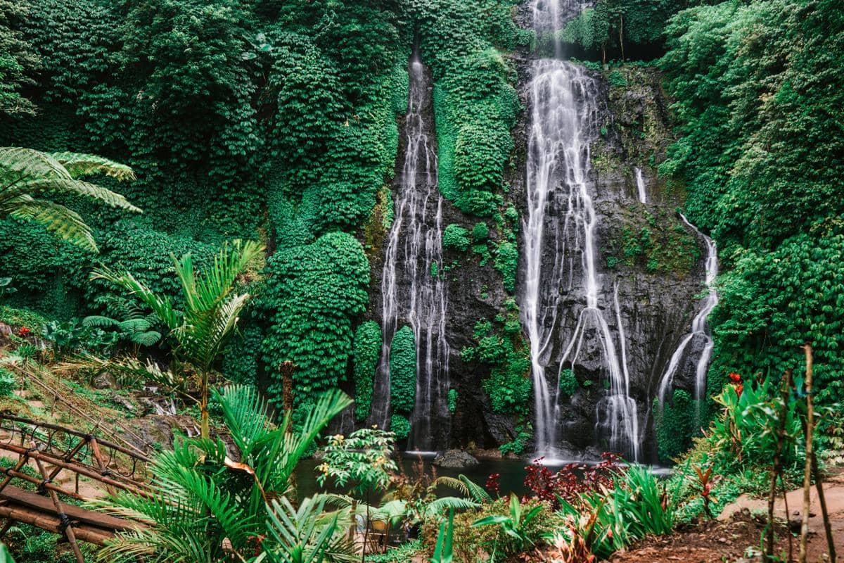Ilustrasi air terjun Taman Wisata Alam Gunung Baung menggambarkan destinasi alami yang cocok untuk healing.
