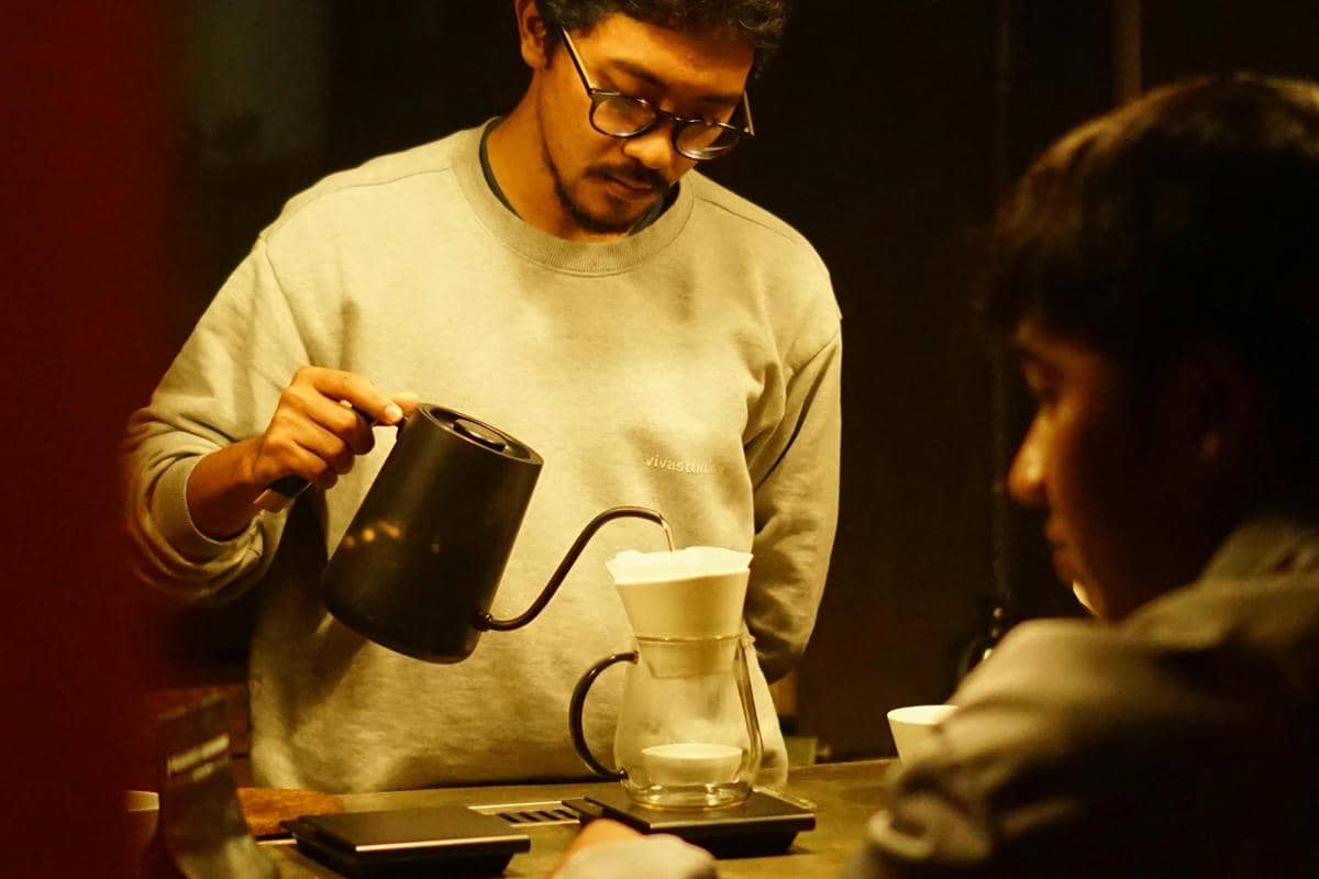 Ilustrasi barista REBINS menyeduh kopi dengan teknik manual brew.